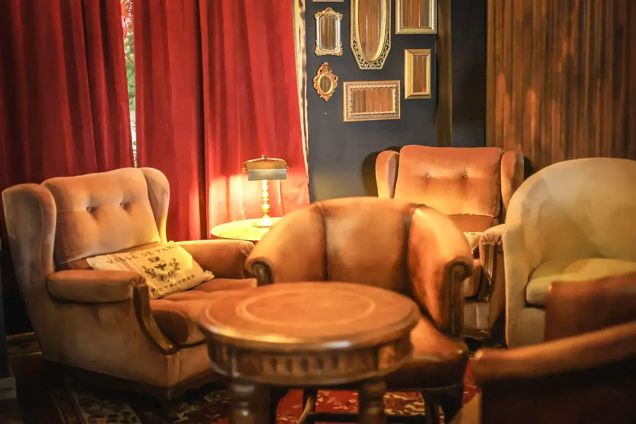 Velvet armchairs, red curtains and vintage gold mirrors inside Klandestino Lounge, a lounge bar in North Miami
