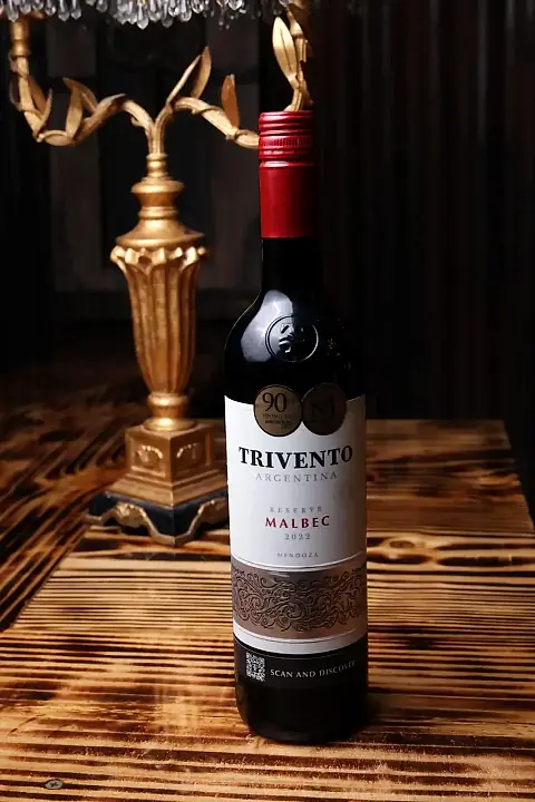 A bottle of Argentine Malbec next to a gold lamp at Klandestino Lounge